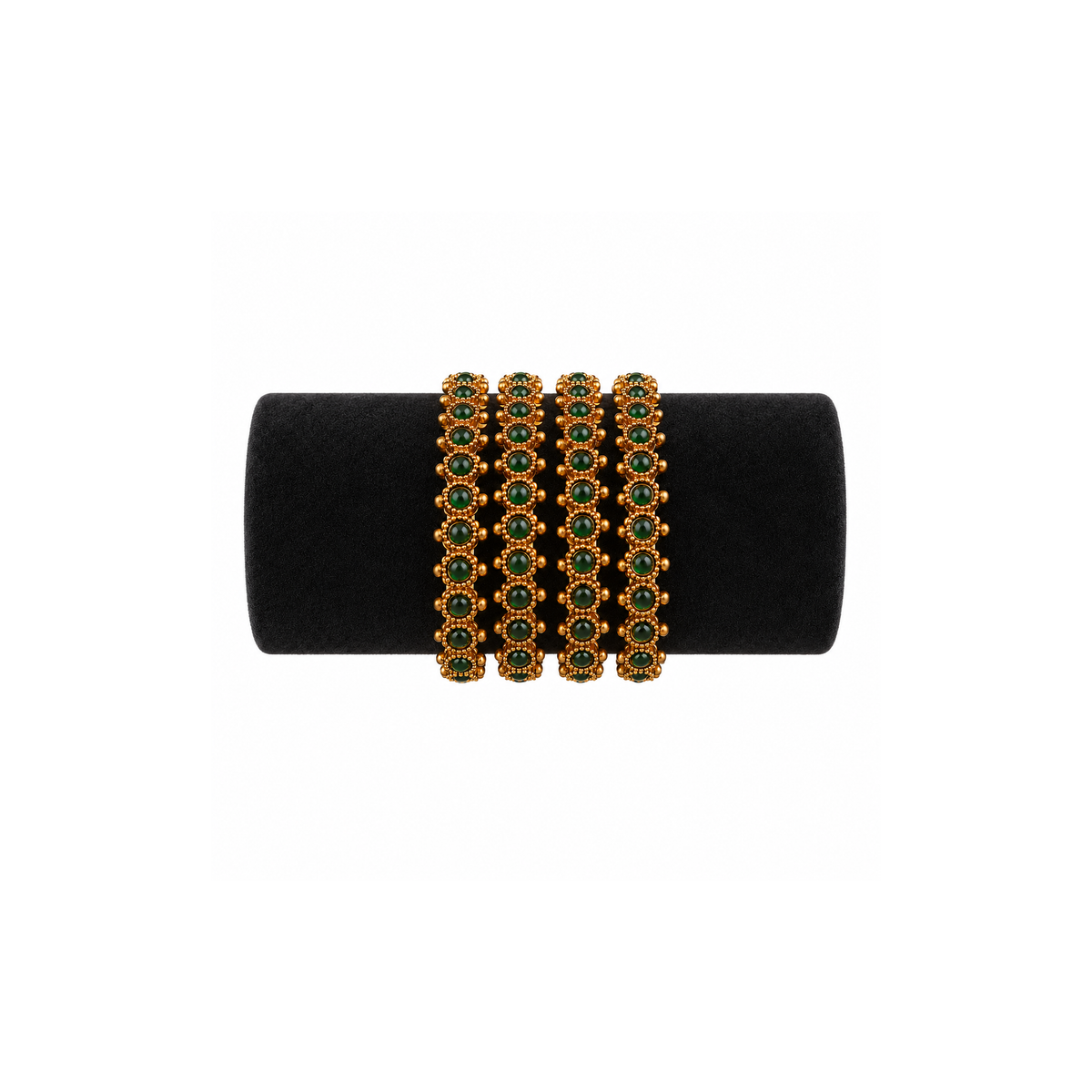 Four antique gold-tone bangles with oval deep-green stones on black velvet