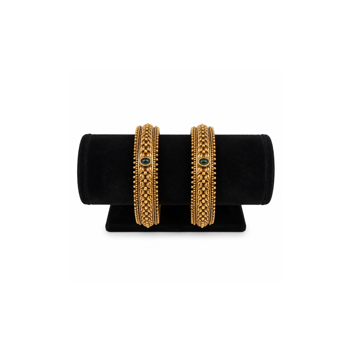 Two green stone braided antique gold-tone bangles on black velvet