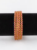 Four gold-tone bangles with round ruby-pink stones, front view