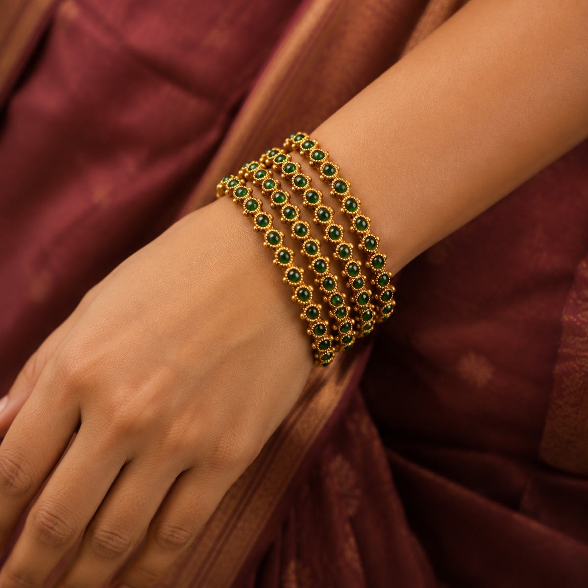 Indian woman wearing four green stone antique gold-tone bangles