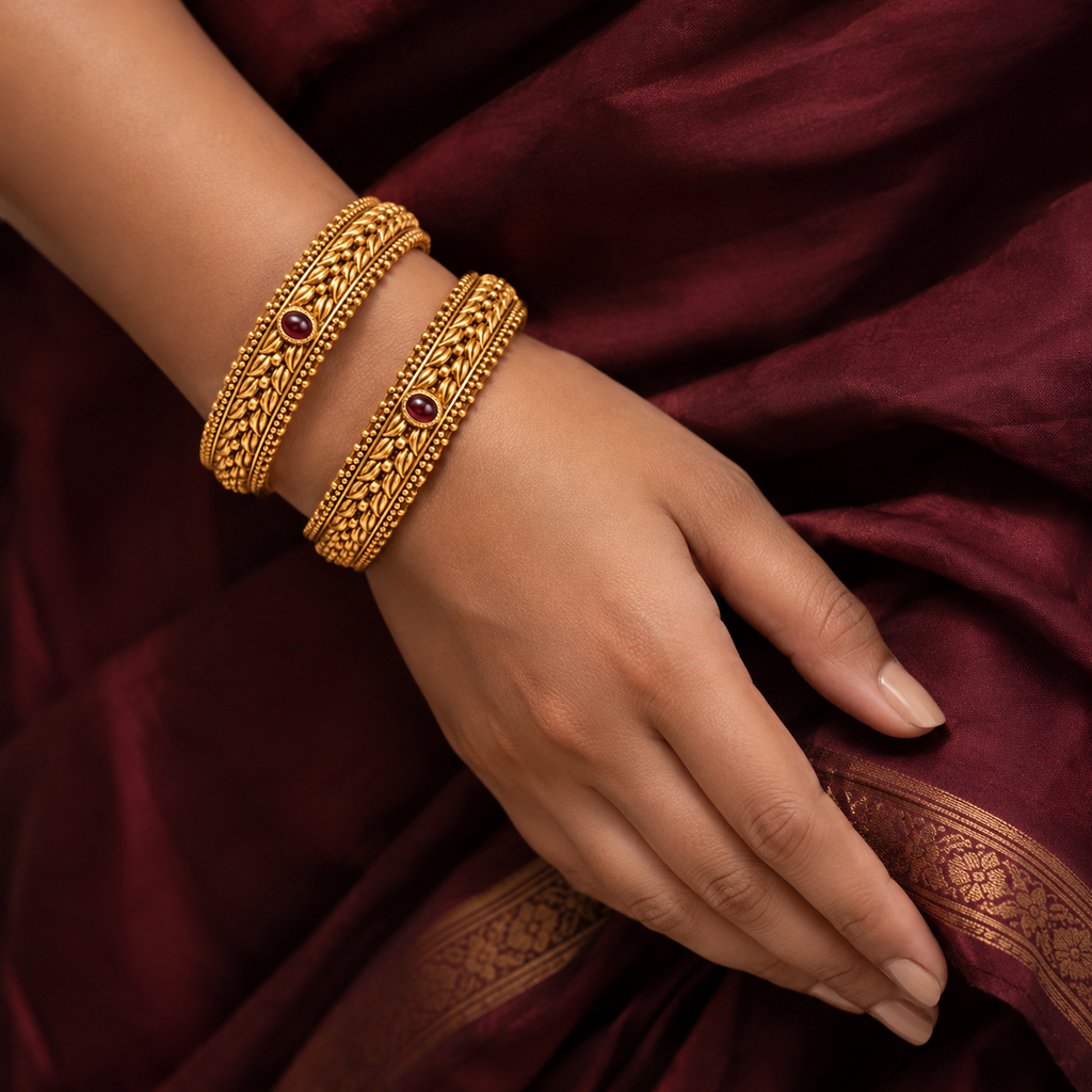 Indian woman wearing two red stone braided antique gold-tone bangles