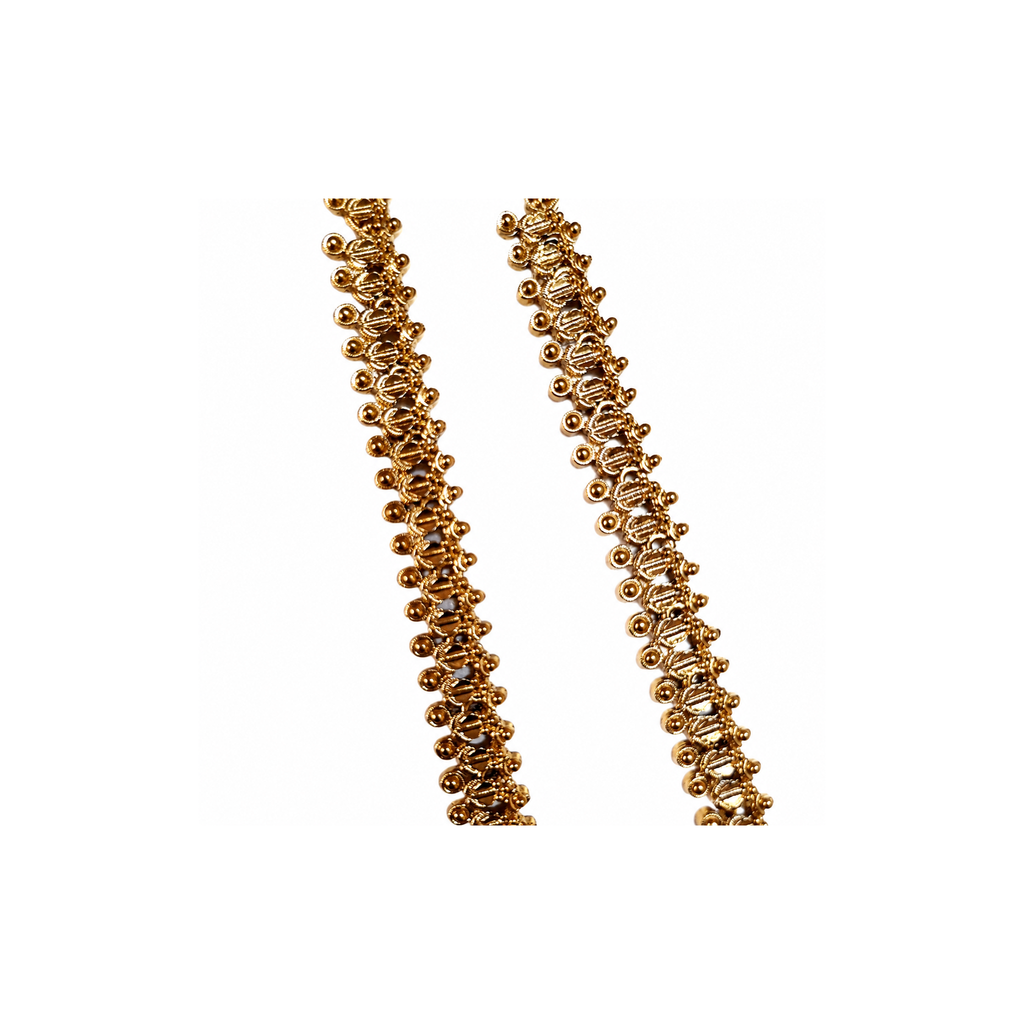 Close view of repeating antique gold-tone paisley links with round bead edging