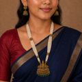 Close view of woman in navy saree wearing the long temple necklace set