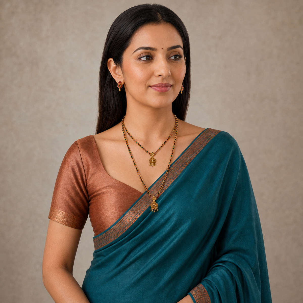 Indian woman wearing layered ruby emerald necklaces and matching earrings